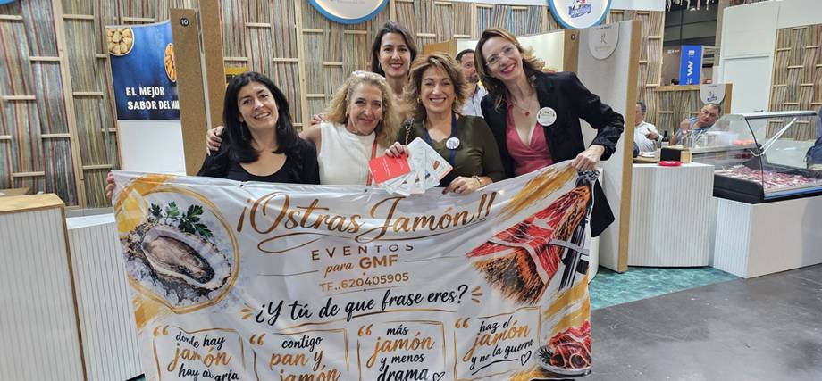 Cinco mujeres posando junto a un cartel de Ostras Jamón en un stand de Gastrónoma Valencia 2026